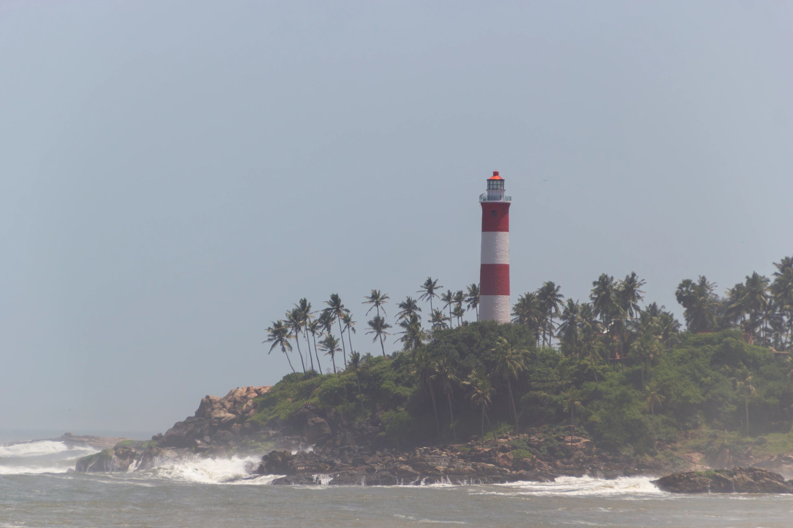 Kerala lighthouse and rocky coast with waves